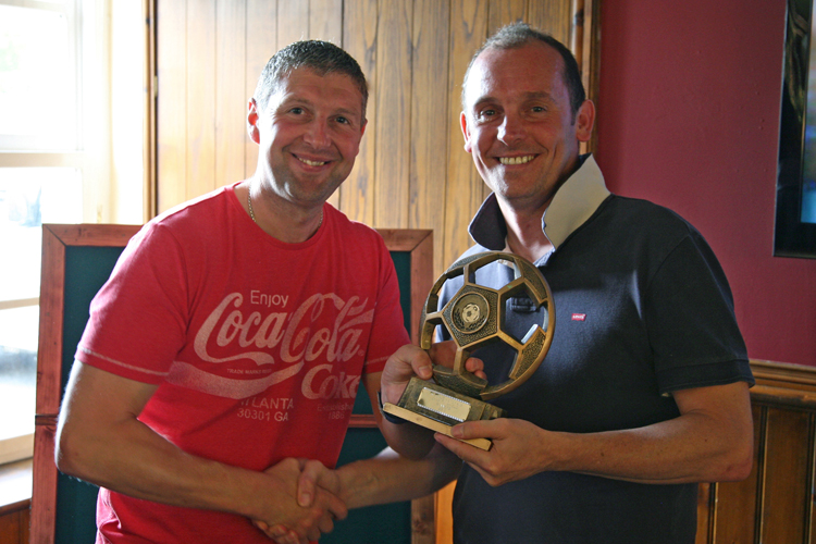 Anthony Woosey collects the trophy from Carl Worsnip
